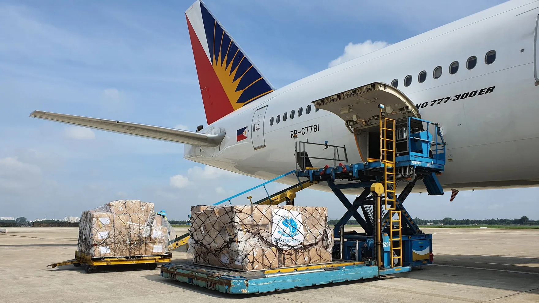 Cargo boxes being loaded onto a freighter aircraft at an airport