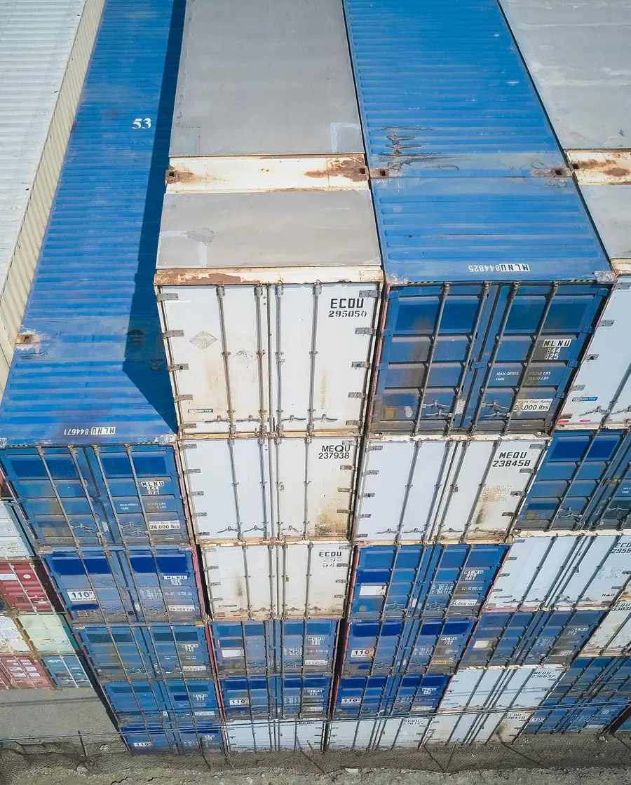 Aerial view of neatly organized rows of stacked shipping containers
