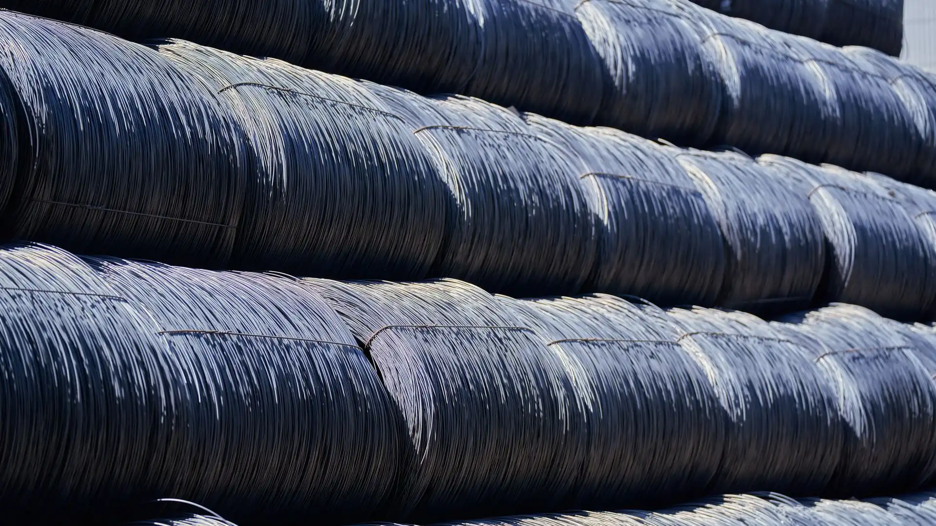 Stacks of industrial steel wire coils stored in an outdoor yard
