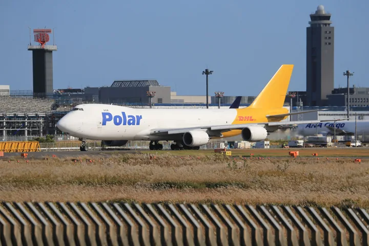A large cargo airplane parked on the tarmac at an airport during daytime.