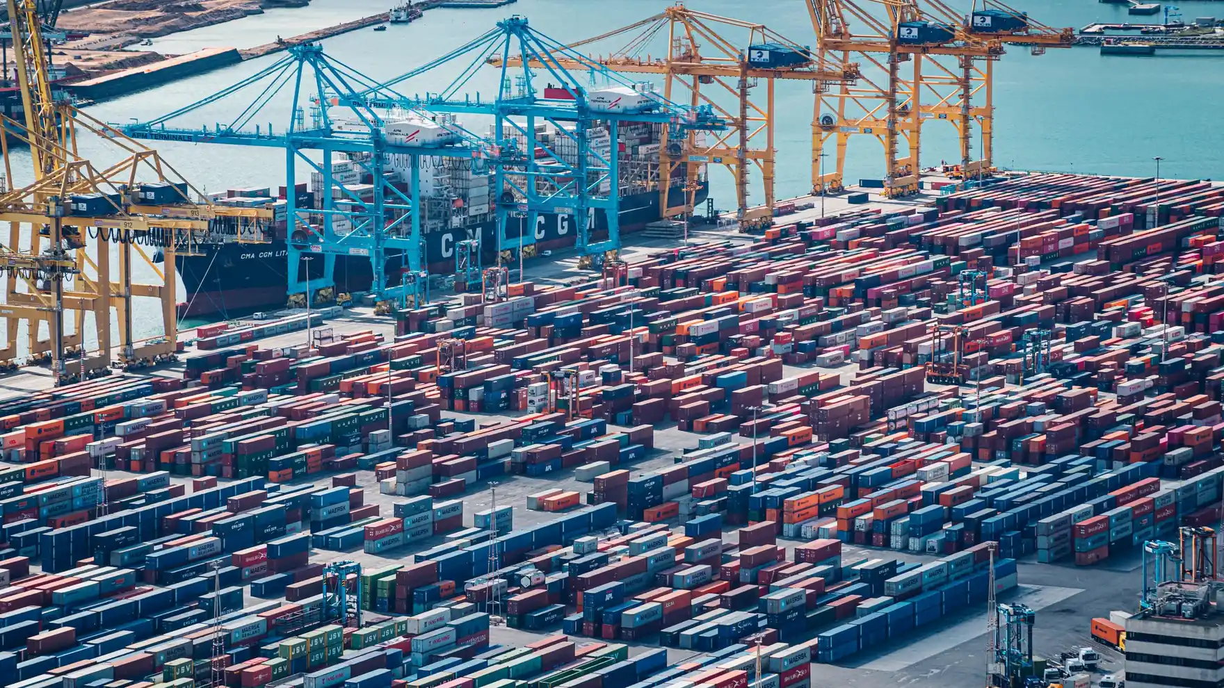 Aerial view of colorful shipping containers staged on a port pier