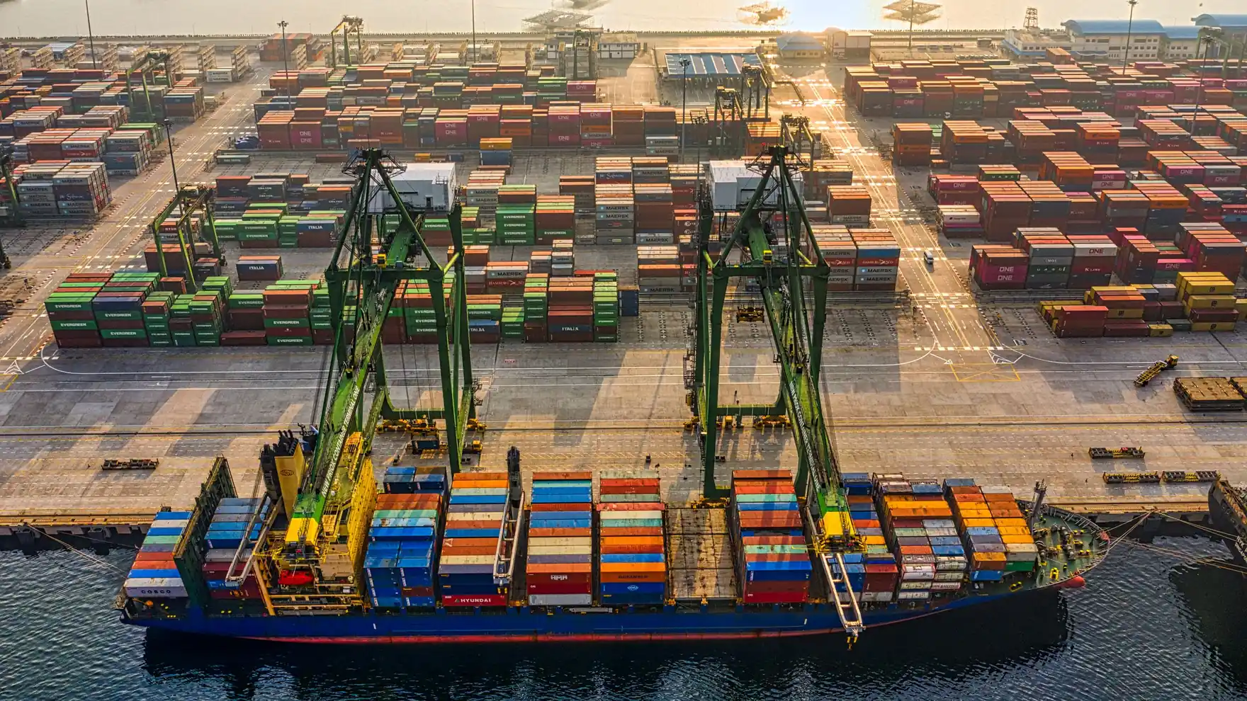 A cargo ship departing a container port, seen from above