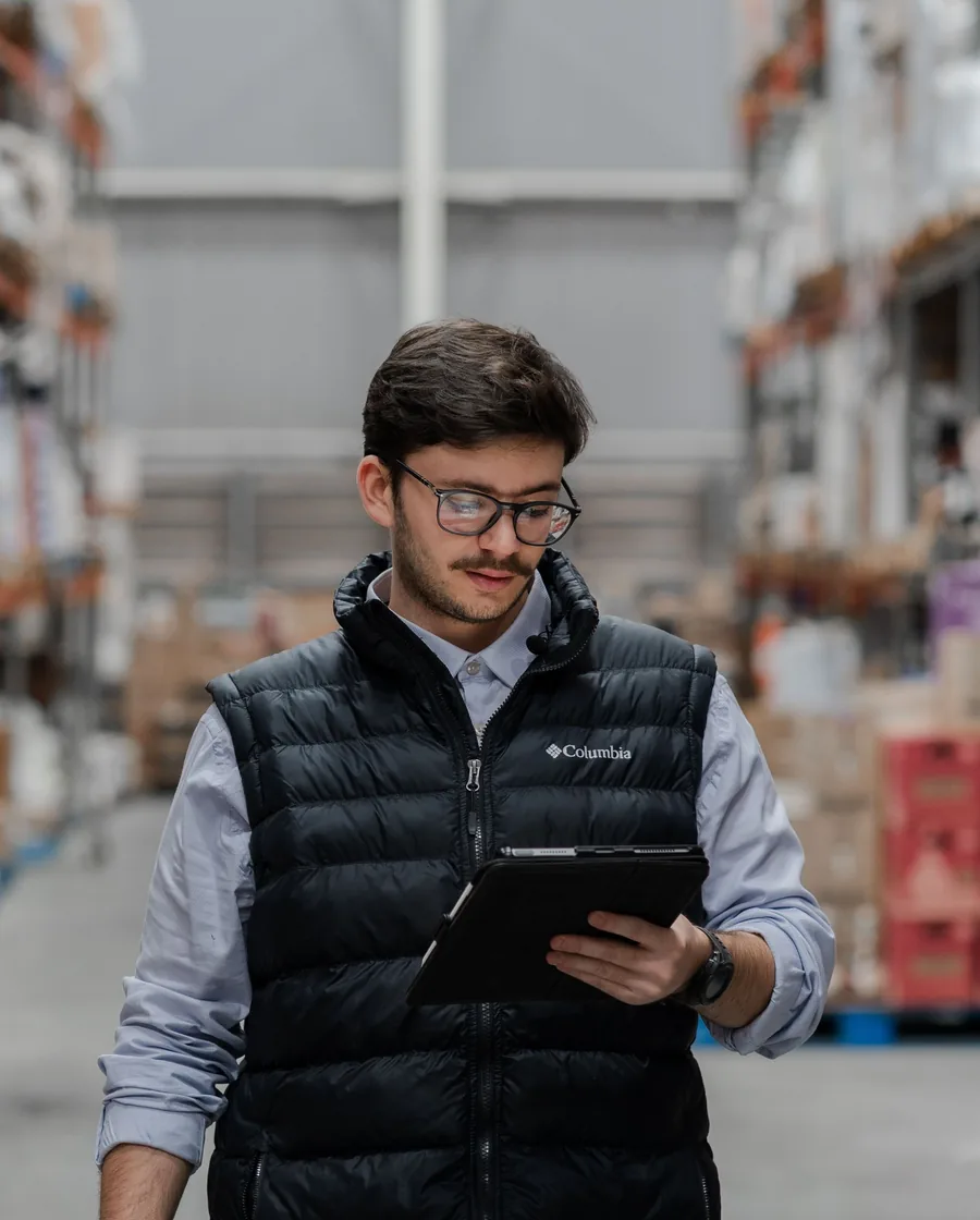 A warehouse worker using a tablet to manage inventory and systems data